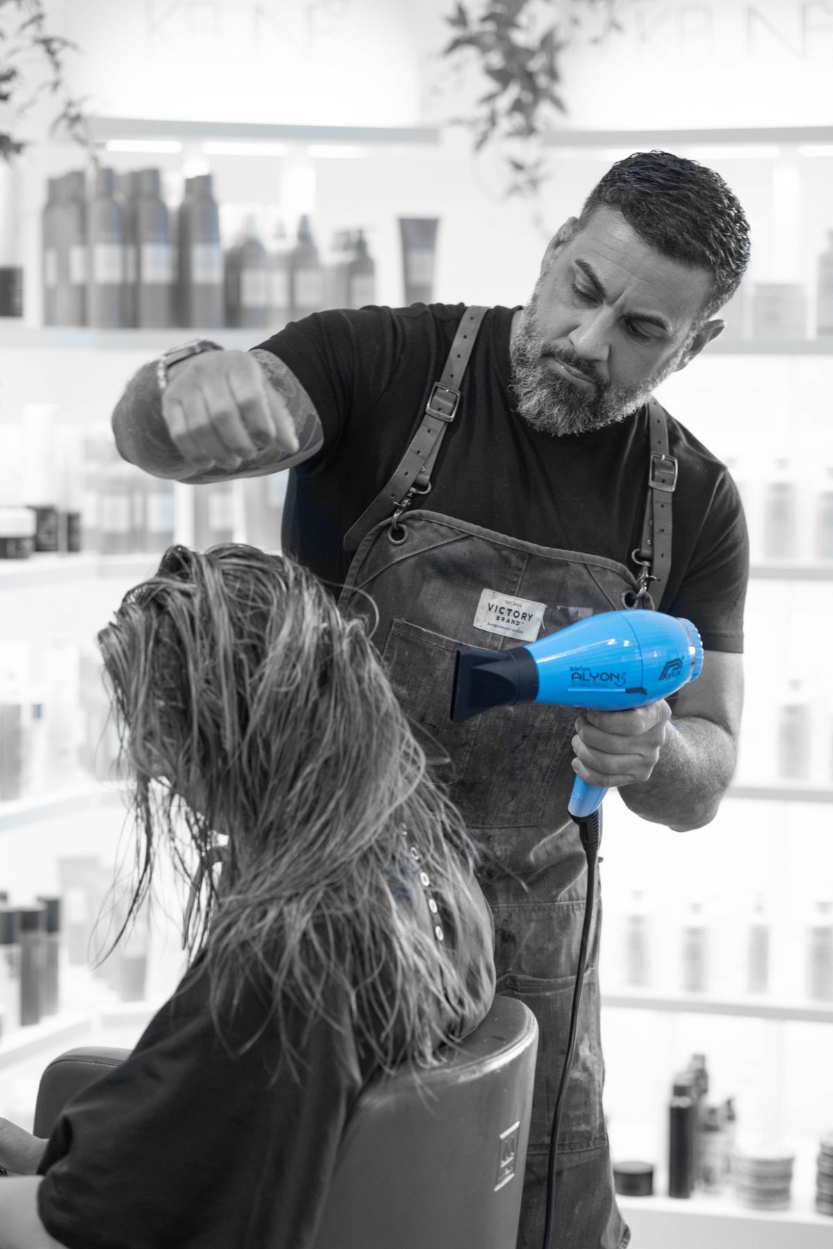 Nick Mirabella blow-drying a client's hair in a salon